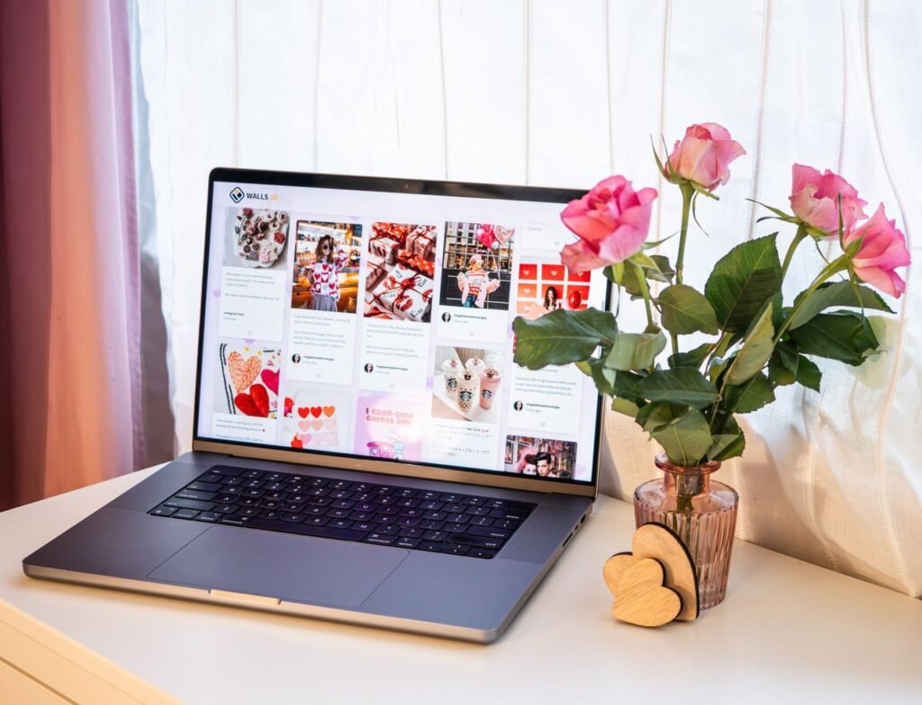 Laptop displaying a website with a flower pot on a desk.